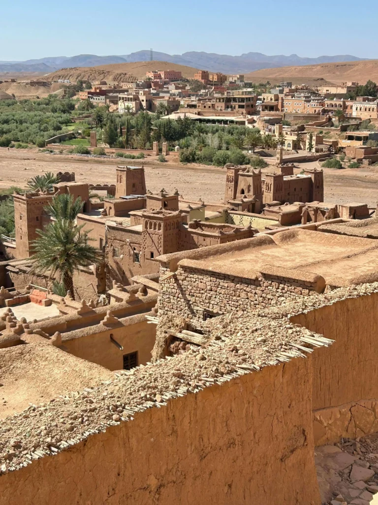 A view over the traditional mud-brick rooftops of a historic Kasbah in Morocco, highlighting the incredible destinations on our adventure motorcycle tours | Una vista sobre los tradicionales tejados de adobe de una Kasbah histórica en Marruecos, destacando los increíbles destinos de nuestras rutas en moto trail.